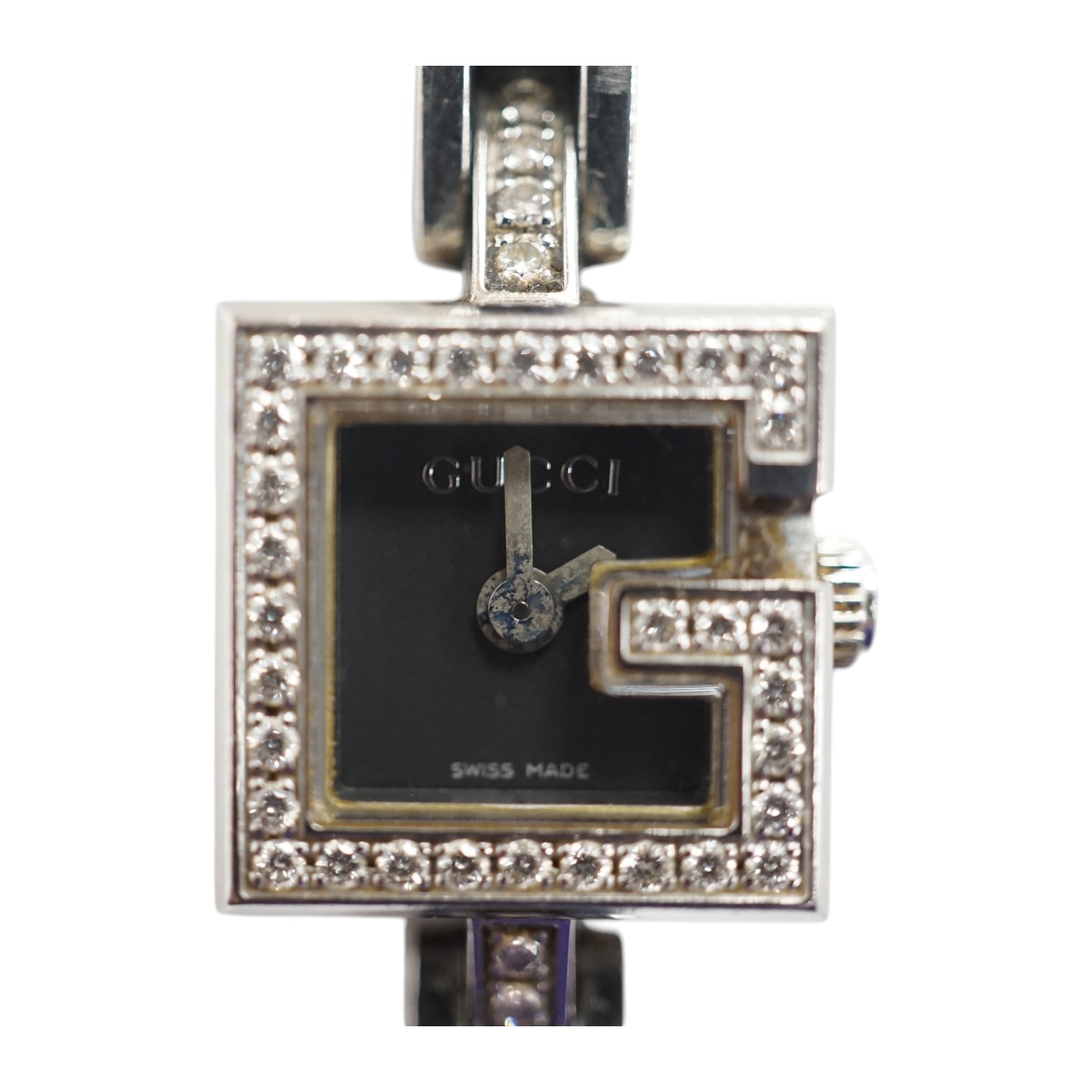 A lady's stainless steel Gucci quartz wrist watch, with G shaped case and diamond chip set bezel, on a stainless steel Gucci bracelet. Condition - fair